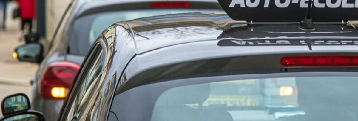 Des véhicules auto écoles roulant dans une ville